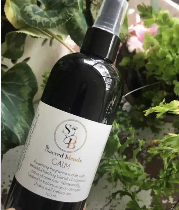 CALM fragrance spray by Sacred Blends in a black bottle with a spray nozzle, labeled for use.